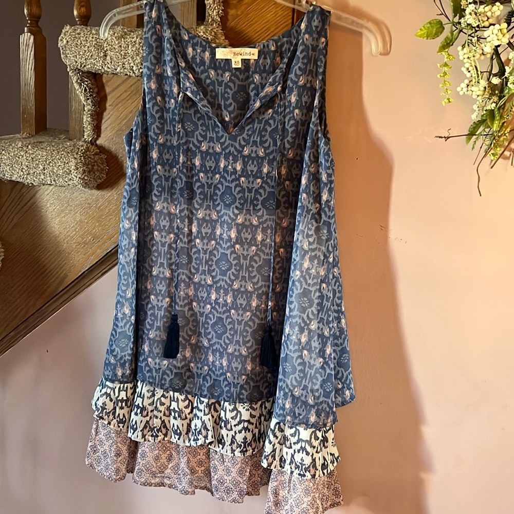 Rewind sleeveless boho style top with tassels and 3-tiered hem. New with tags!